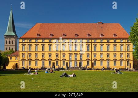 Osnabrueck Castle, students resting on the lawn in the castle garden , Germany, Lower Saxony, Osnabrueck Stock Photo