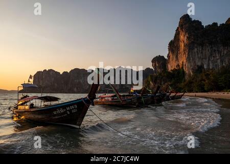 Long tail boats at sunset at Railay beach near Krabi, Thailand Stock Photo