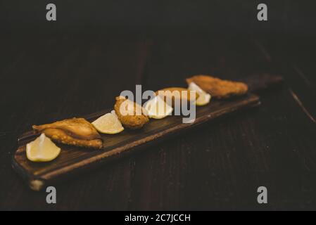 High angle shot of fried food near lemon sliced on a wooden surface Stock Photo