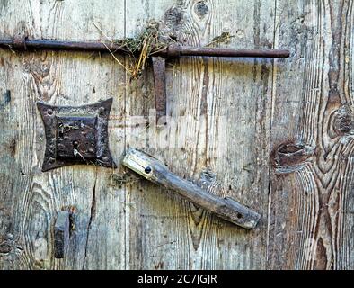 Detail on an old barn door with handle, iron bolt and door lock fitting in South Tyrol Stock Photo