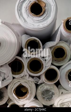 Lot of white textile rolls in a tailors studio Stock Photo