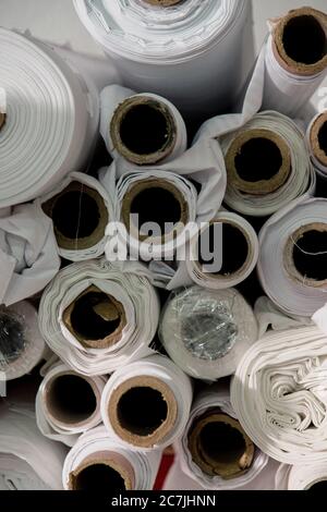 Lot of white textile rolls in a tailors studio Stock Photo