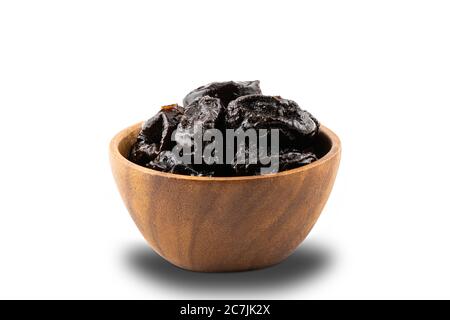 Dried pitted prunes in wooden bowl on white background with clipping path. Stock Photo