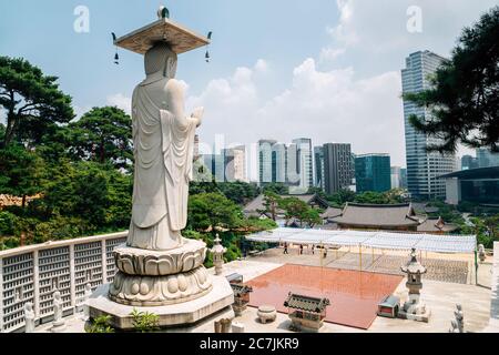 Buddha statue with modern cityscape at Bongeunsa temple in Seoul, Korea Stock Photo