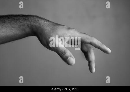 Greyscale shot of a males hand showing a gesture Stock Photo