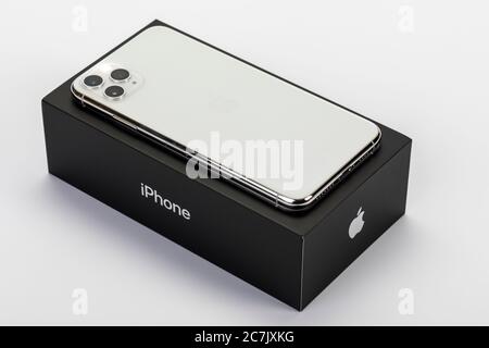 Apple iPhone 11 Pro Max on original packaging, back, three-camera system, flash, white background, Stock Photo