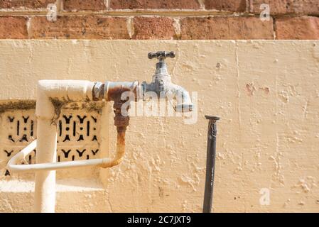 A garden tap painted the same colour as the wall it sits near, outside a Federation house in Mudgee, New South Wales, Australia Stock Photo