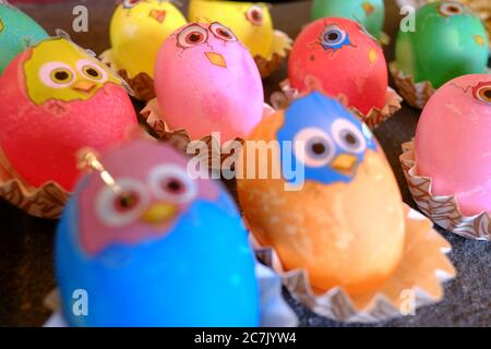 Colored Easter eggs with stickers looking like freshly hatched chickens Stock Photo