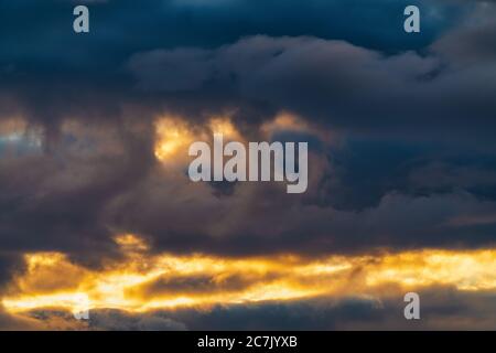 Impressive clouds in sky illuminated by rays of sun at sunset to change weather. Soft focus, defocus, motion blur multicolored cloudscape abstract Stock Photo