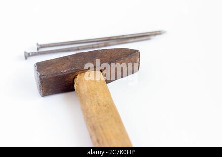 An old hammer and large nails on a white background. Stock Photo