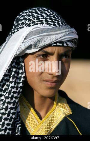 Portrait of a teenage boy of Arabian decent wearing a keffiyeh on his head in the ancient town of Harran in Turkey. Stock Photo