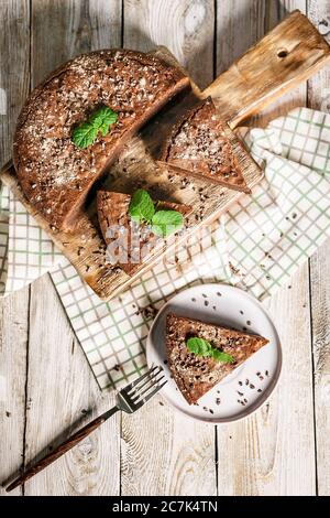 Homemade chocolate cake brownie on a wooden cutting board. Cooking delicious desserts at home. Vertical shot Stock Photo