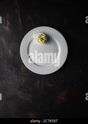 Bread with avocado spread, radishes and fresh chives on three white plates. Overhead shot with copy space. Stock Photo