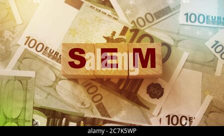 SEM on Wood cubes Search Engine Marketing. on 100 euro bills. Business Concept. Stock Photo