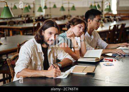 Group of young multinational students studying together in library of university Stock Photo