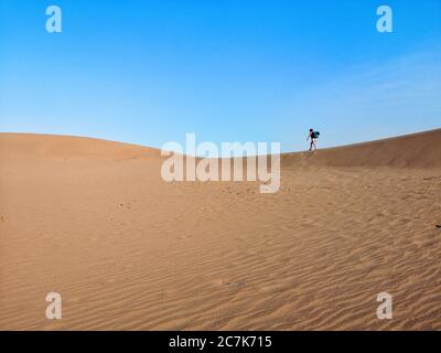 Lone woman hikes on sand dune in Death Valley, Nevada, USA Stock Photo