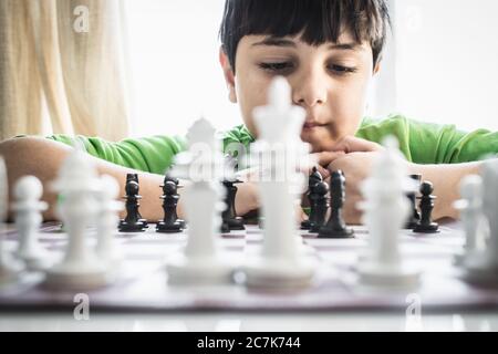 Little boy playing chess.Smart kid.Little genius Child. Intelligent gam. Stock Photo
