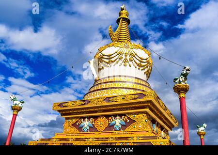 A monument of Buddhist statue . it contains beautiful paintings in golden and white color with blue sky behind