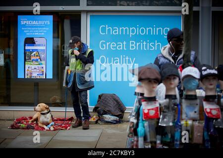 Manchester Market Street, Big Issue seller with dog and mask Stock Photo