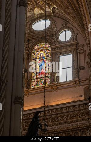 The stained glass window of the Immaculate Heart of Virgin Mary high over the Grand Chapel and High Altar of Cordoba's Mosque-Cathedral. Stock Photo