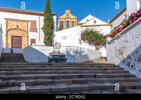 A view up the stairs of Cuesta de Bailio in Cordoba, to a colourful befry and the Biblioteca Viva de Al-Andalus Stock Photo