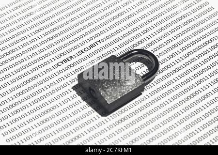 Closeup shot of a lock on a white surface with cyber security, ones, and zeros written on it Stock Photo
