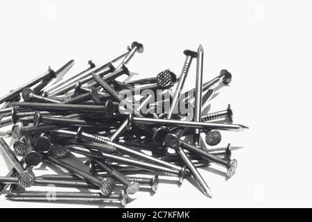 Closeup shot of metal nails on a white surface Stock Photo