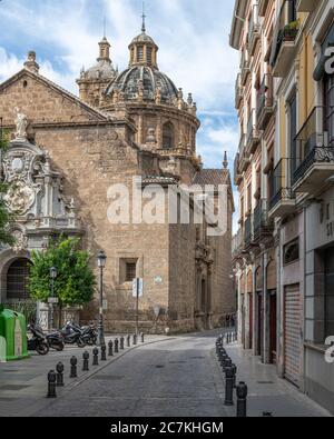 The dome and tower of the Jesuit Iglesia de San Justo y San Pastor rise over Calle de San Jeronimo and University Square in Granada. Stock Photo