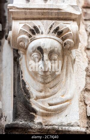 A carved woman's face looks out from a door pillar at the Real Conservatorio Superior de Musica 'Victor Eugenia' in Granada. Stock Photo