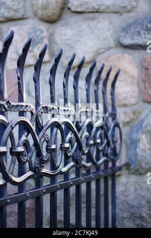 Vertical closeup shot of the beautiful patterned details of an iron fence Stock Photo