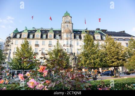 Oslo, Norway - September 10, 2019: Grand Hotel Oslo in rose flowers greenery on summer day in sunset light Stock Photo