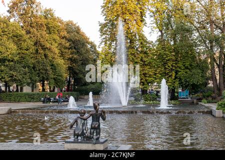 Oslo, Norway - September 10, 2019: Children sculpture near fountain in city center. Sunset golden light summer day Stock Photo