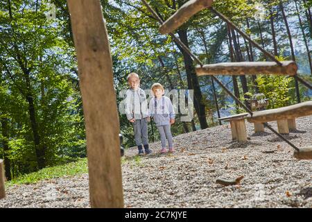 Little boy and a girl standing in the playground during the daytime Stock Photo