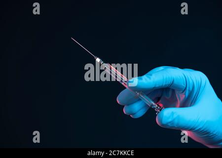 Symbol, corona, science, research, vaccine, danger, right, syringe, cannula, hand, bottom right Stock Photo