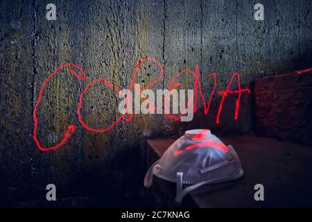 Symbolic picture, menekel on concrete wall, Corona lettering, handwriting with red laser beam, respirator Stock Photo