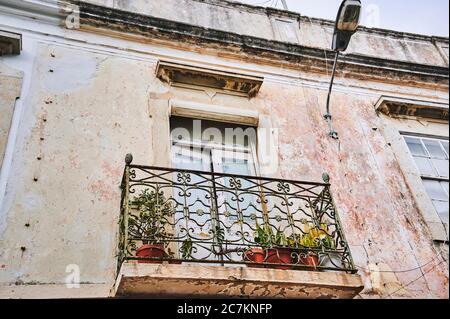 Europe, Portugal, Algarve, Litoral, Sotavento, Faro District, Olhao, balcony on a weathered house facade, metal railings with ornaments Stock Photo