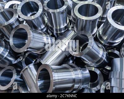 abstract industrial shiny steel production background with cnc machined pipes - selective focus and lens blur technique Stock Photo