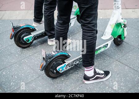 Berlin, Germany - July, 2020: Closeup of a person using a Lime E-scooter or Electric scooter Stock Photo