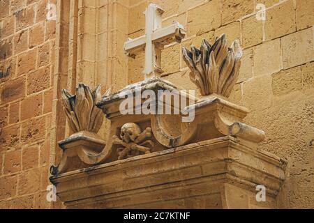 Beautiful shot of the sculpture of religious symbol on the old stone building made of bricks Stock Photo