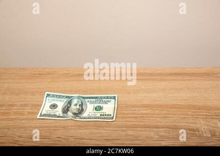 100 Dollar on wooden table Stock Photo