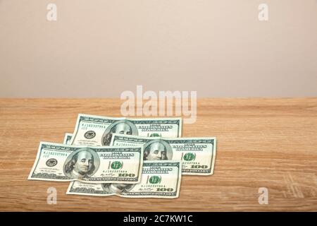 100 Dollar on wooden table Stock Photo