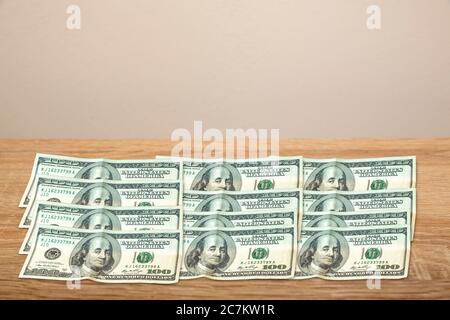 100 Dollar on wooden table Stock Photo