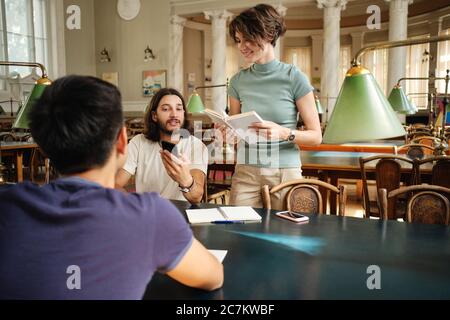 Group of young students happily studying together in library of university Stock Photo