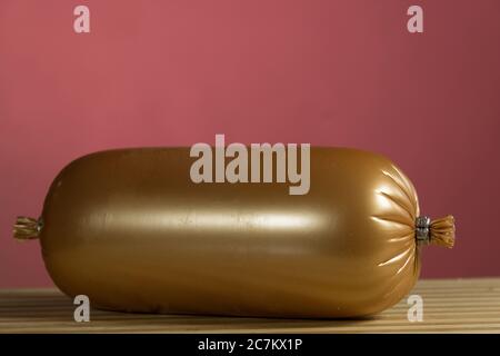Ham sausage on the wooden blackboard. On a burgundy Stock Photo