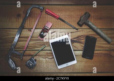 Display of hand tools on a wooden surface and a tablet and smartphone with space for your text Stock Photo