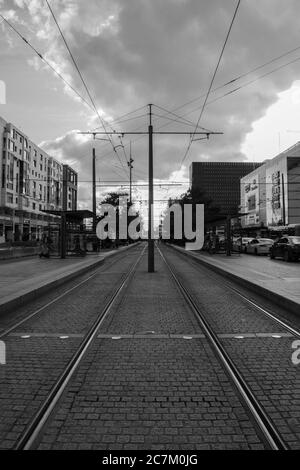 Vertical grayscale shot of rails in the city Stock Photo