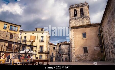 Saturday market at the side of the Sant Pere monastery in the Placa Prat de Sant Pere in Besalú. The monastery church was built in the 12th century. The place has been recognized as a cultural asset (Bien de Interés Cultural) in the Conjunto histórico-artístico category since 1966. Stock Photo