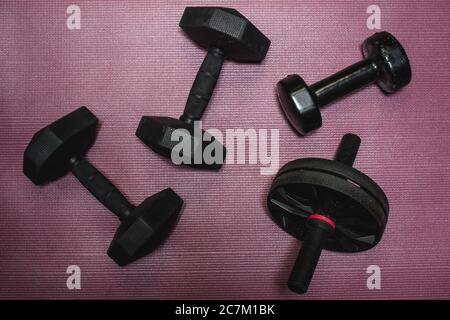 High angle shot of dumbbells in different weights on a purple surface Stock Photo