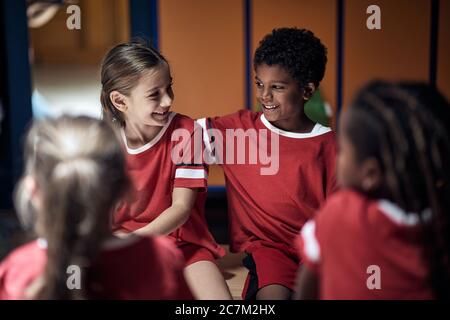 Smiling girl and boy friends  in good mood  before training  in changing room. Stock Photo