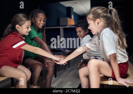 Team of children team doing high five before match or training. Stock Photo